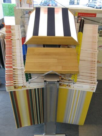 Ausstellung mit Markisenstoffen und Mustern für textile Terrassenüberdachungen im Geschäft.