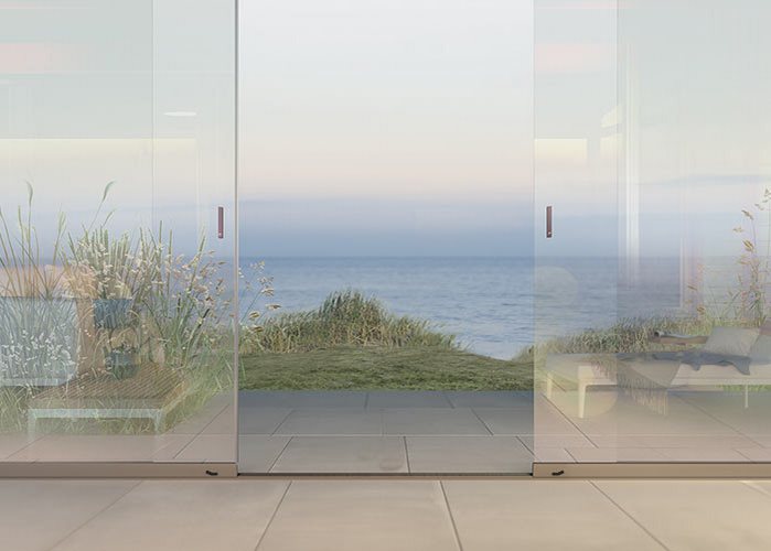 Große Glas-Schiebetüren mit Meerblick, moderner Wohnraum und Terrasse am Strand.